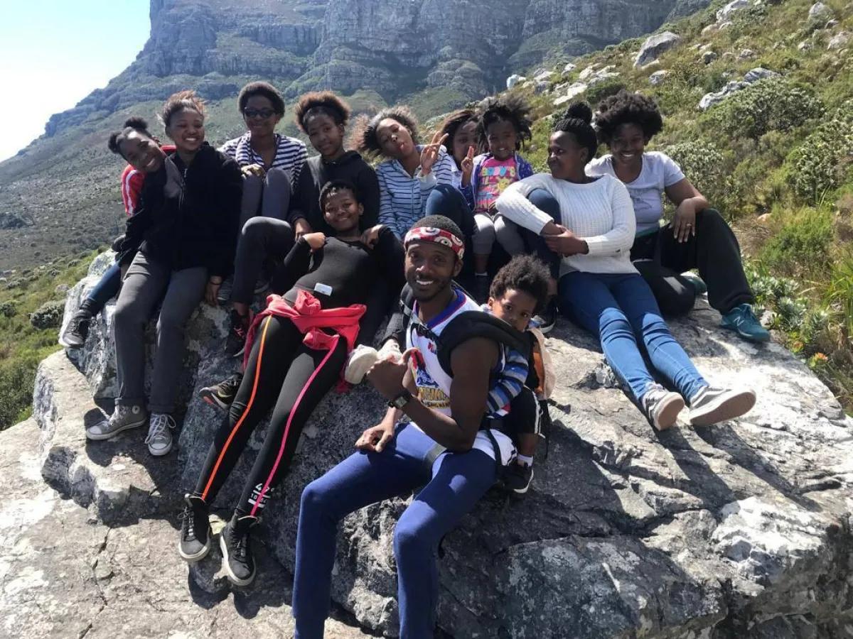 Dr. Ivana Parker, Hiking Table Mountain with a group of youth from Gugulethu township , and her children. Foundational activities for Baleka Wellness (founded by her husband), where she mentored several young women, encouraging them to pursue careers in science and advocating for education and wellness.