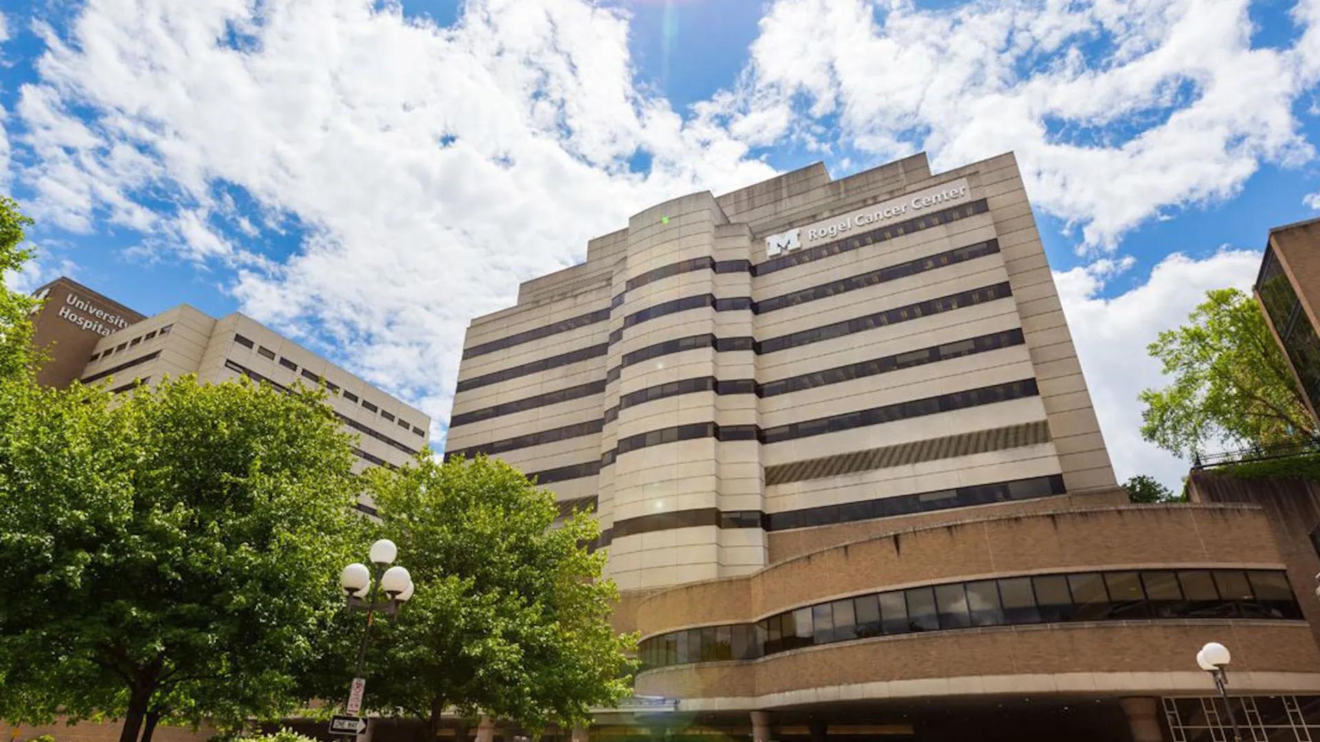 exterior front entrance to rogel cancer center with blue skies and building sign
