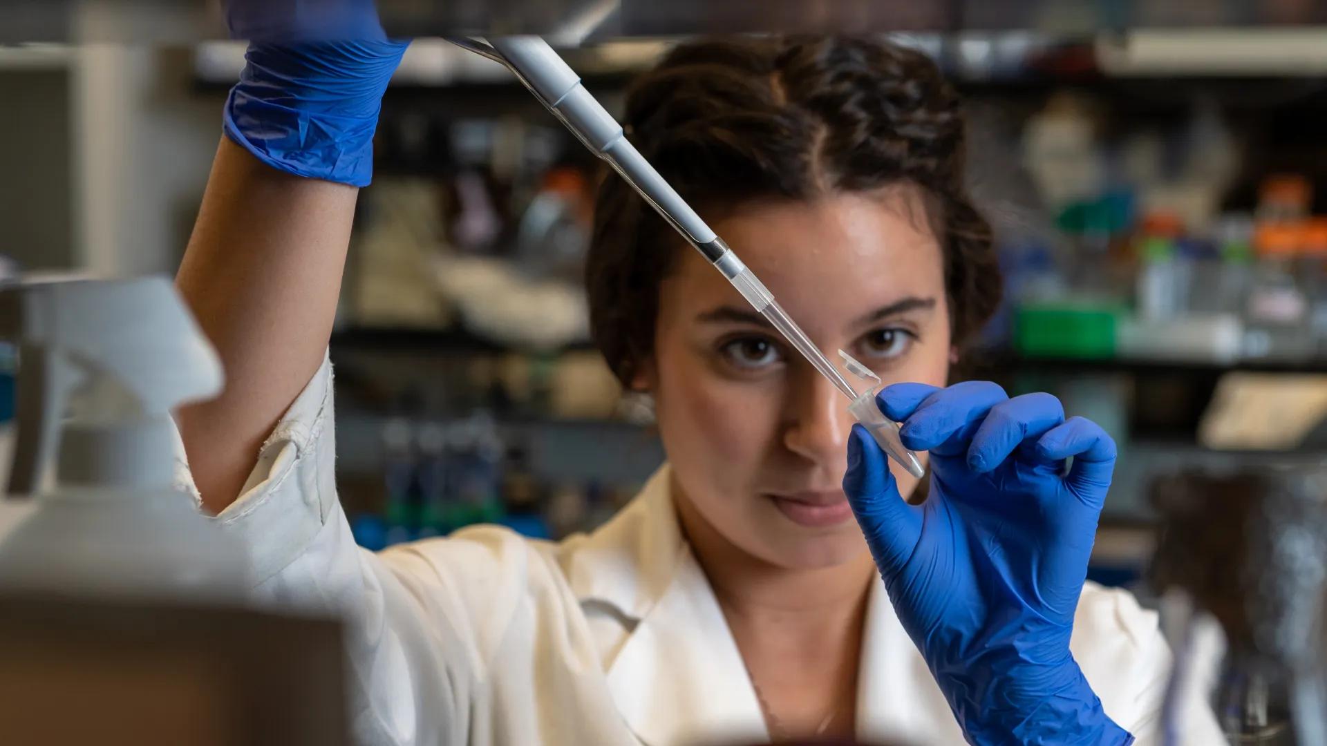 Biological Chemistry Hds Lab Area. Girl uses dropper to put liquid into small test tube 