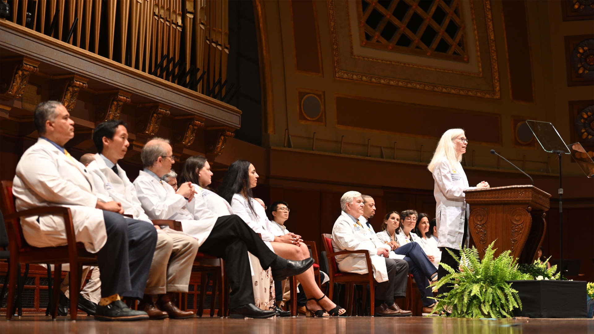 Michigan Medicine leaders seated on the stage at Hill Auditorium
