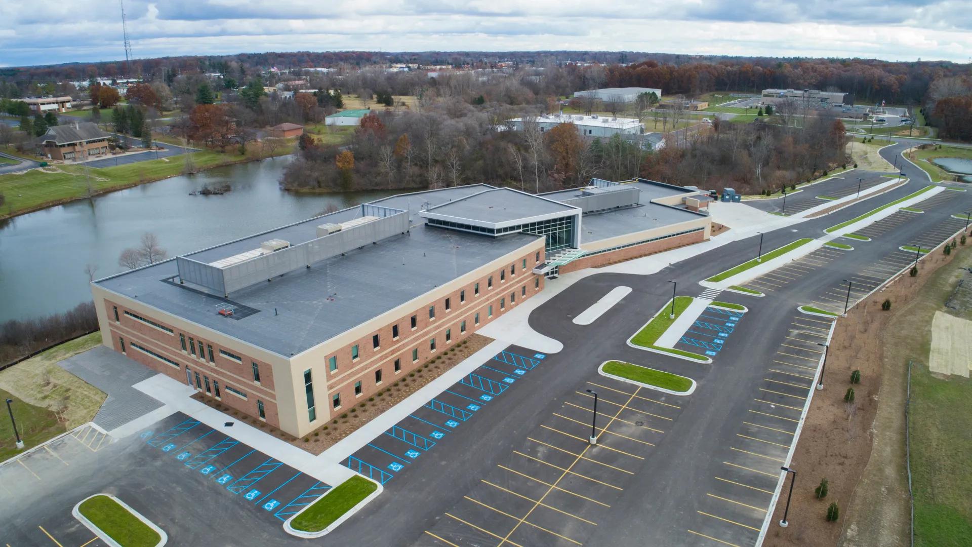a building with a parking lot and a river