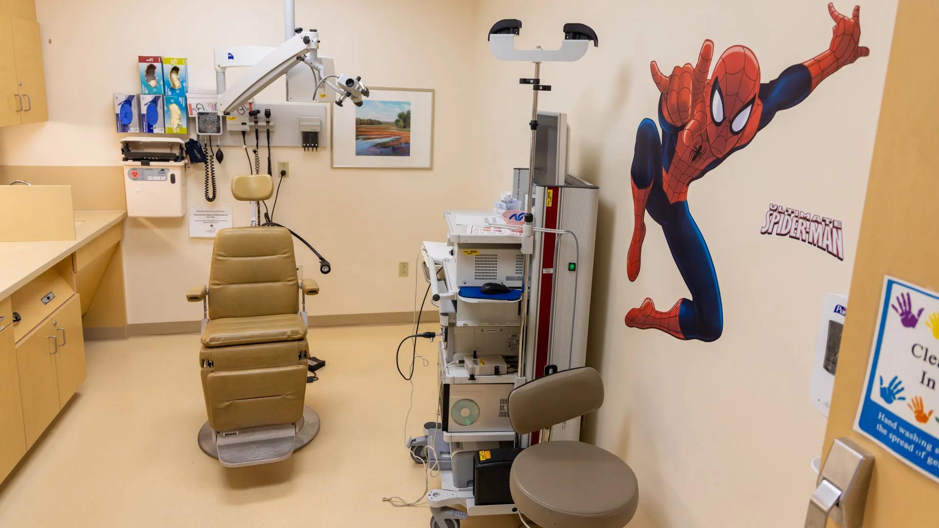 peds clinic room with a chair and a decal of spiderman