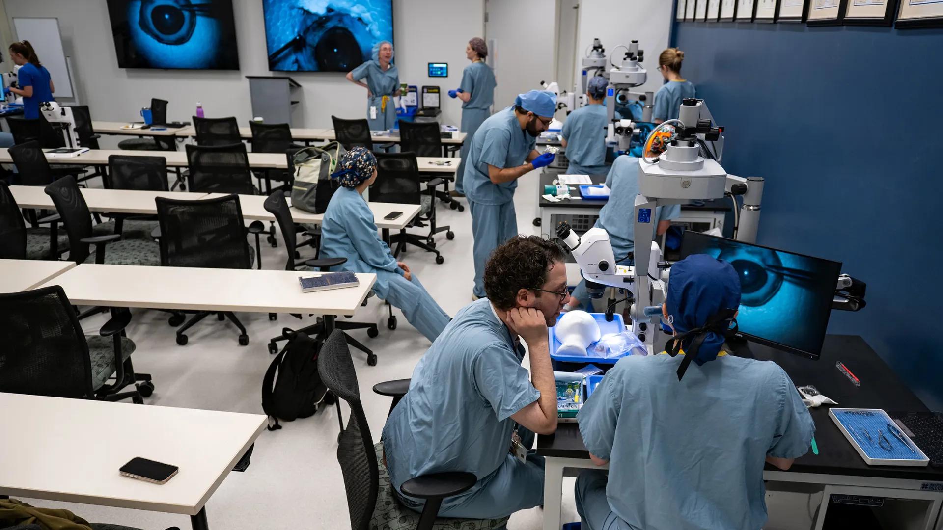Ophthalmology residents practice surgical skills at microscopes in the wet lab.