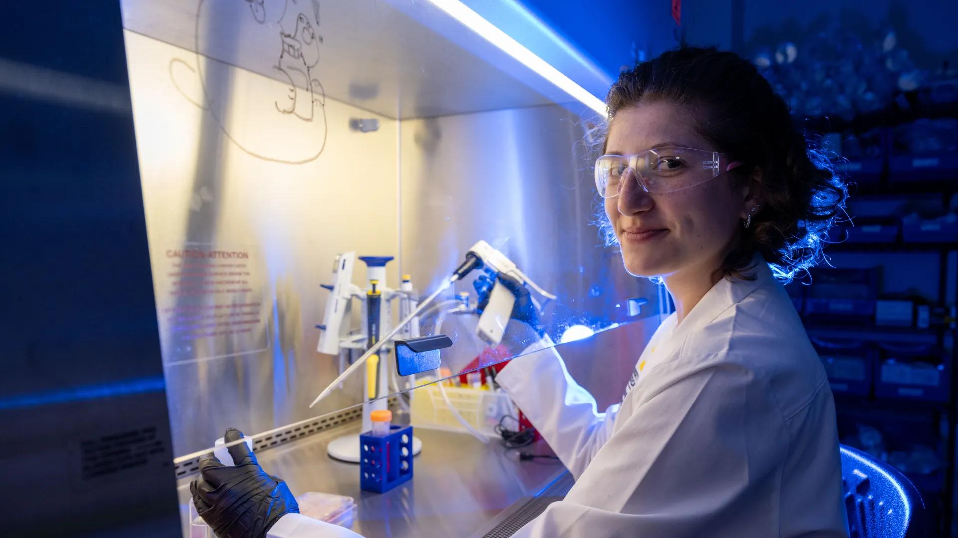 scientist in labcoat dispensing liquid