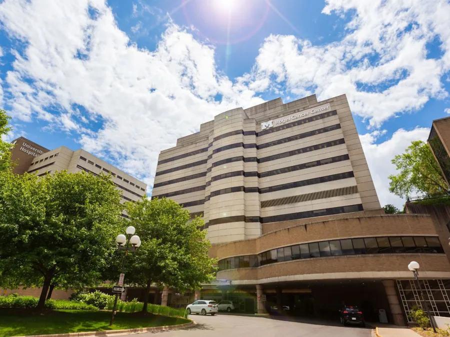 exterior front entrance to rogel cancer center with blue skies and building sign