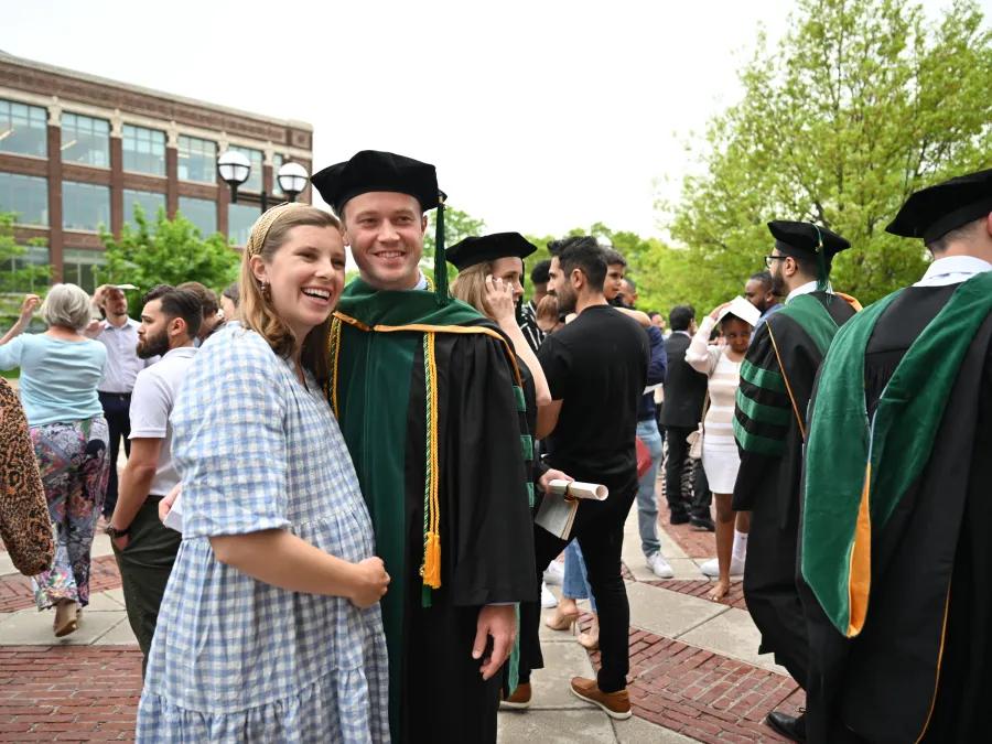 A couple posing for the camera on graduation day