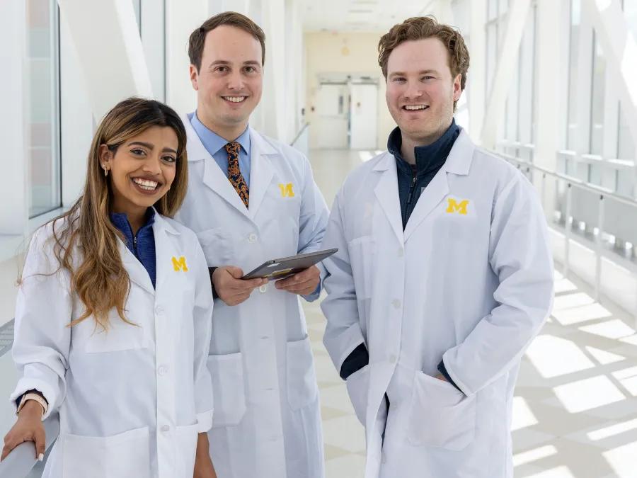Photo of three faculty members standing in the cvc hallway