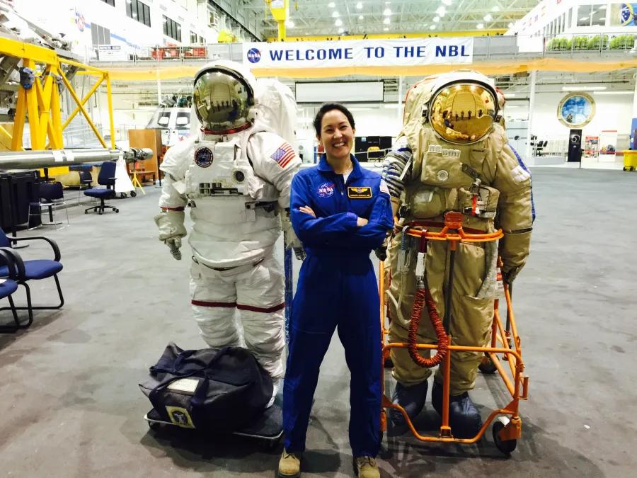 Woman standing by astronaut gear