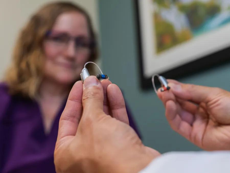 A close up shot of a hearing aid being held by a provider