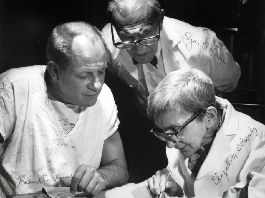 a group of men looking at a piece of paper