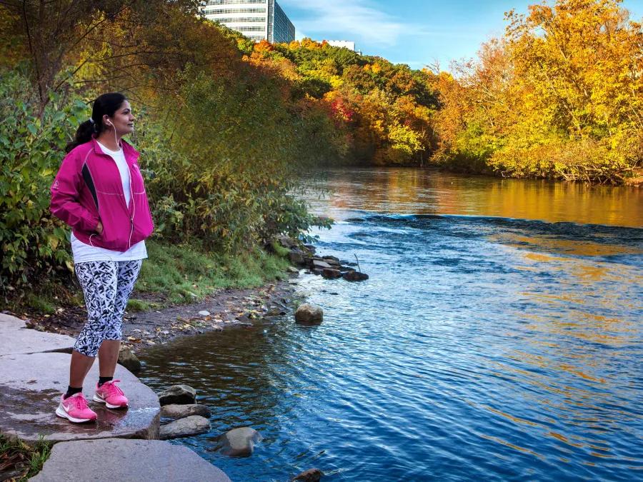 A person standing at a riverbed in Ann Arbor