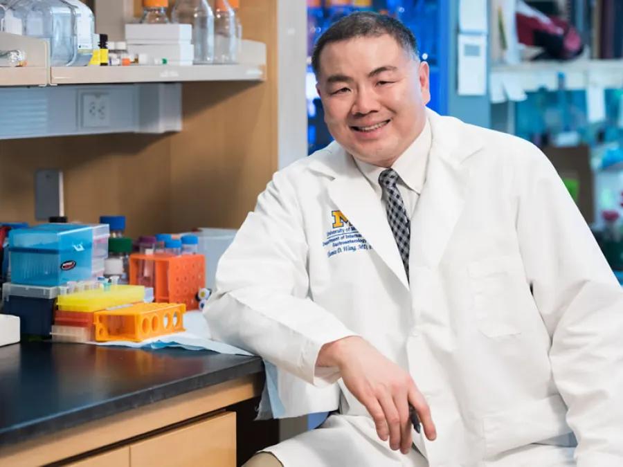 Thomas Wang sits in his lab and smiles