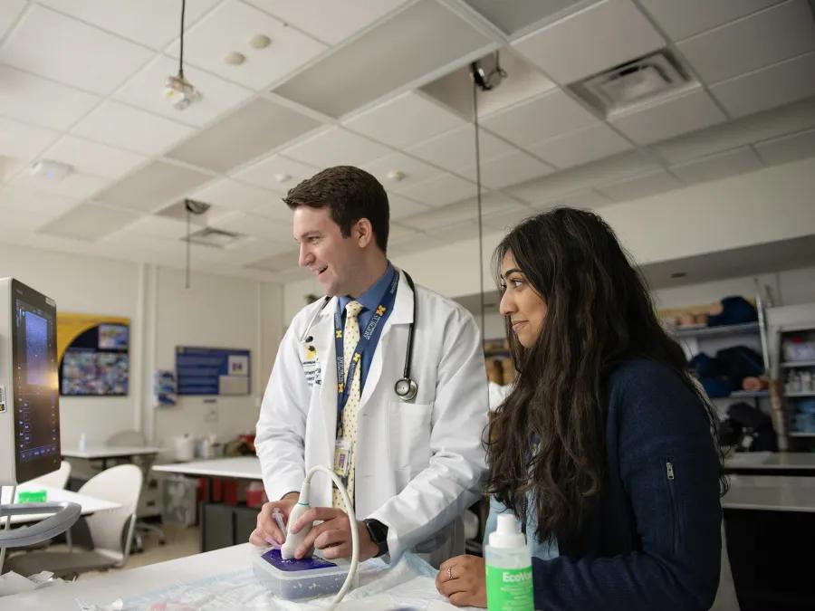 teacher smiles while helping student 