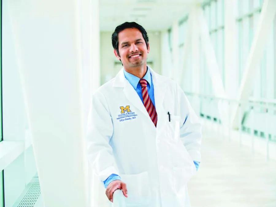 Smiling photo of Aditya Pandey, MD, standing in a brightly-lit hall.