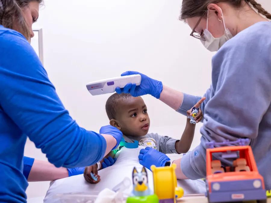 Two oncology physicians play and exam patient