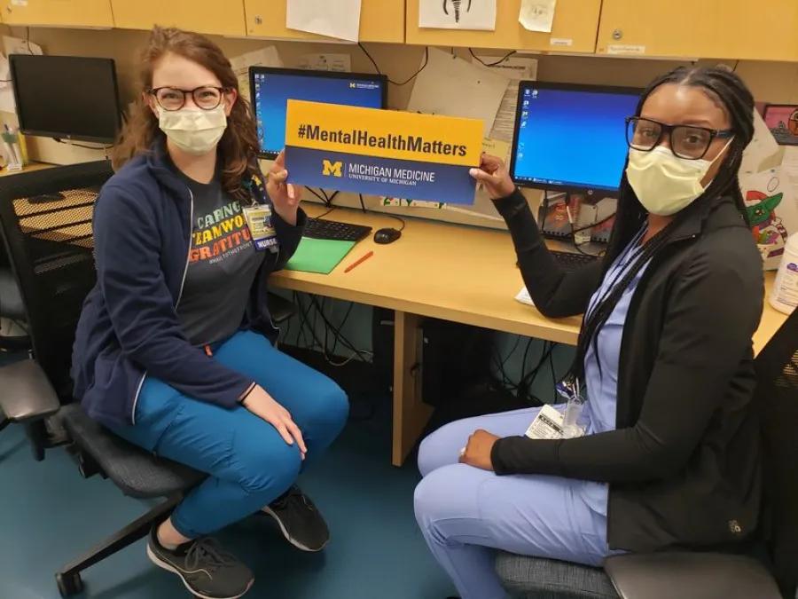 Two people holding up a sign that says "Mental Health Matters"