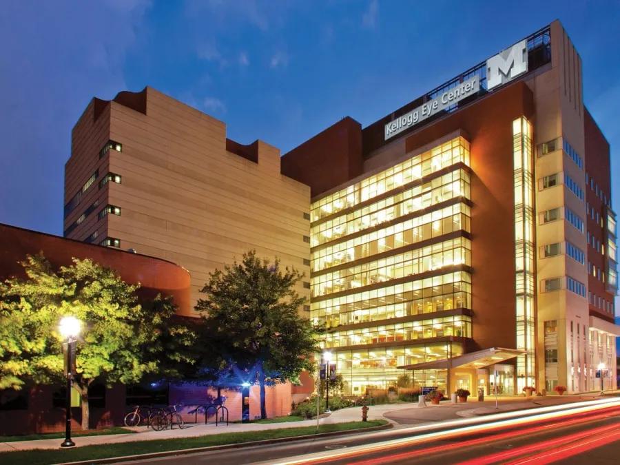 Kellogg Eye Center at night with lights on in the building