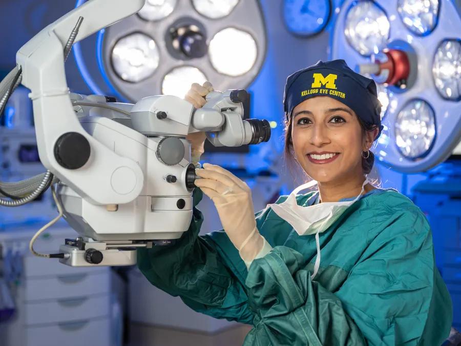 Dr. Valikodath in the operating room next to large lights
