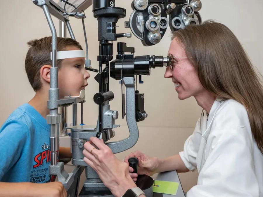 Brianna Tracy, MD examining the eyes of a young patient