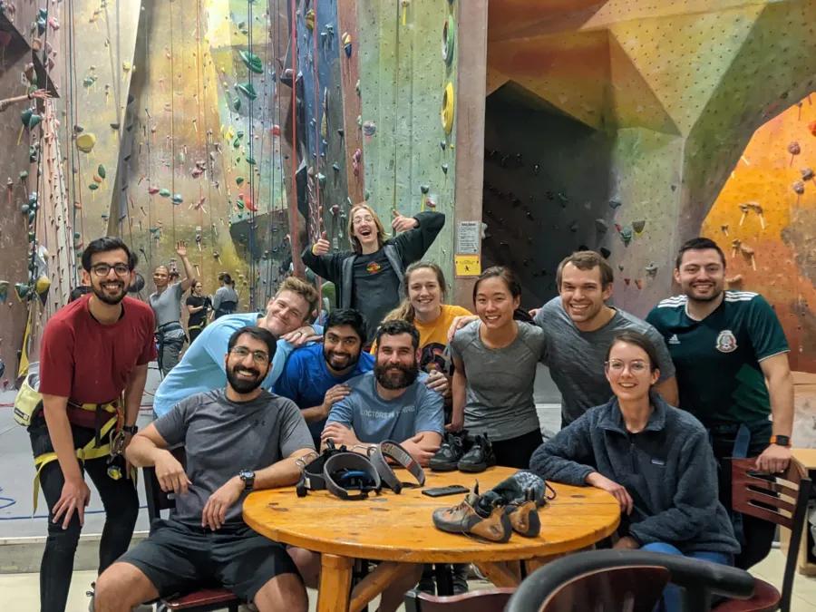 Ophthalmology residents gathered around a table at a climbing wall facility