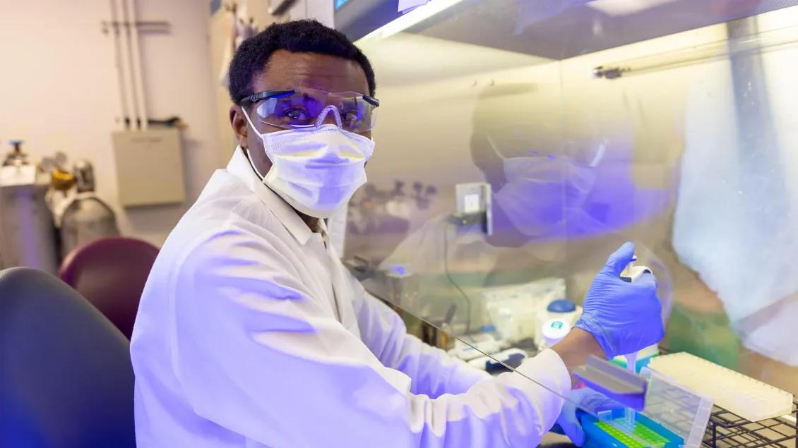 Ph.D. student uses pipette at the hood.