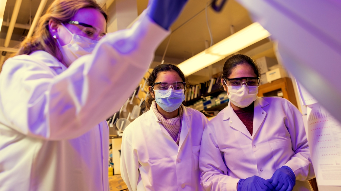 female students in lab coats and goggles 