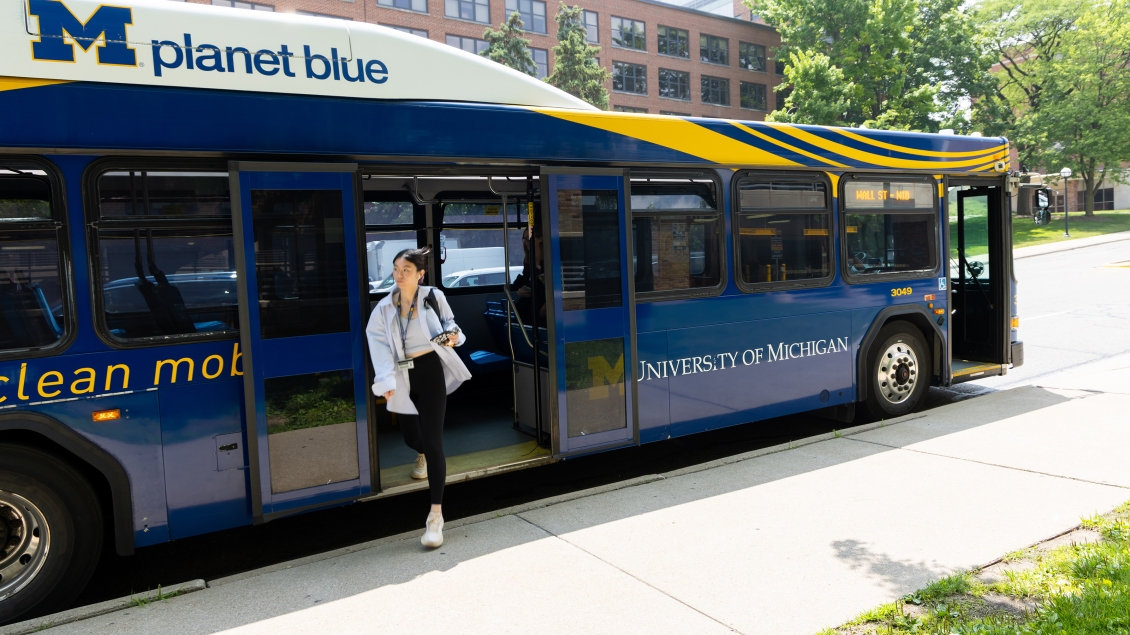Woman exiting a blue bus