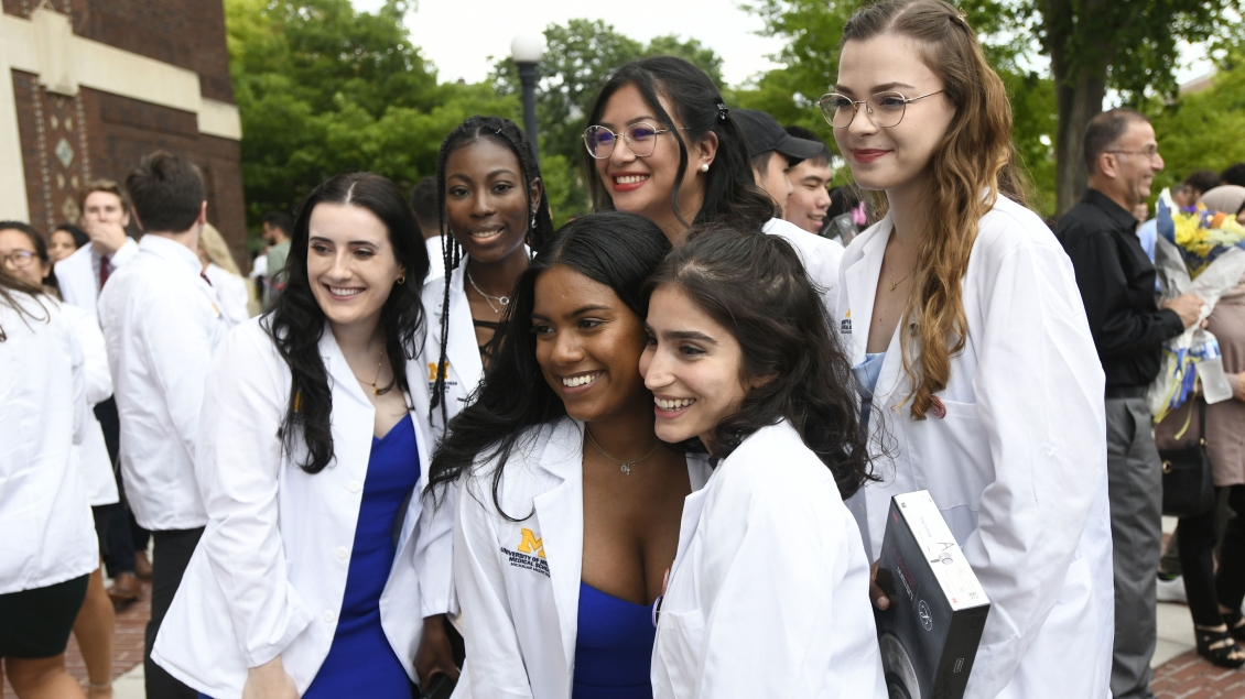 Group of diverse females in white coats posing for the camera