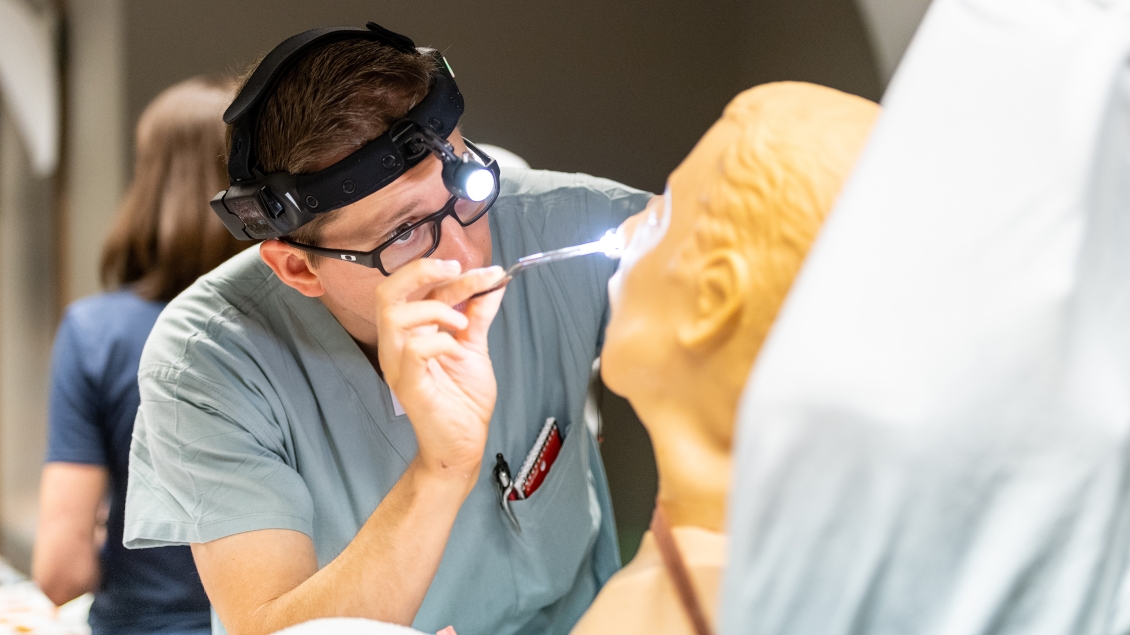 A student practices a nasal exam in the simulation lab