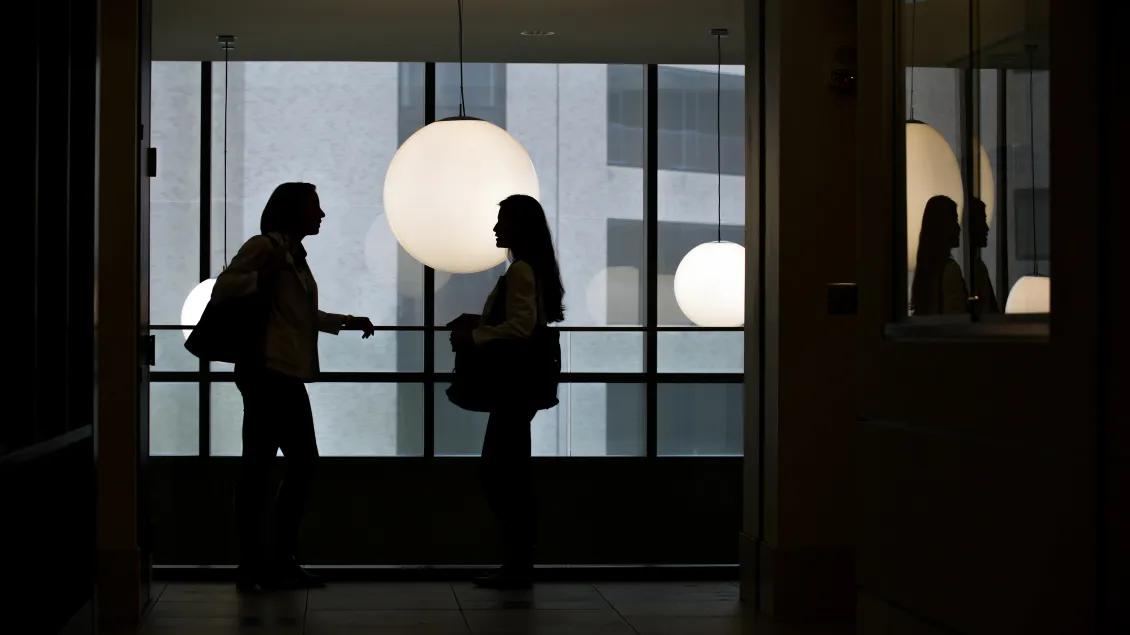Students talking in Taubman library by window