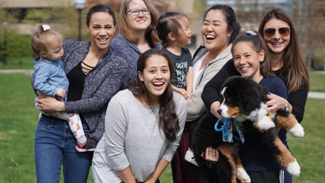 A group of smiling people with a puppy