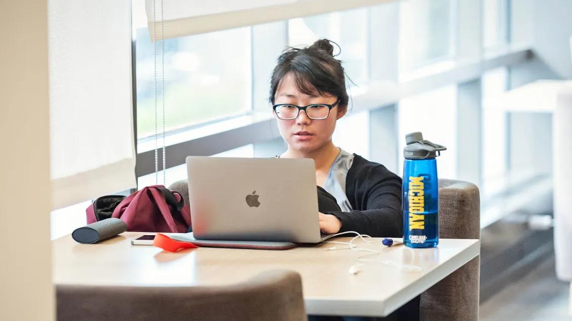 A person sitting at a desk working on a laptop