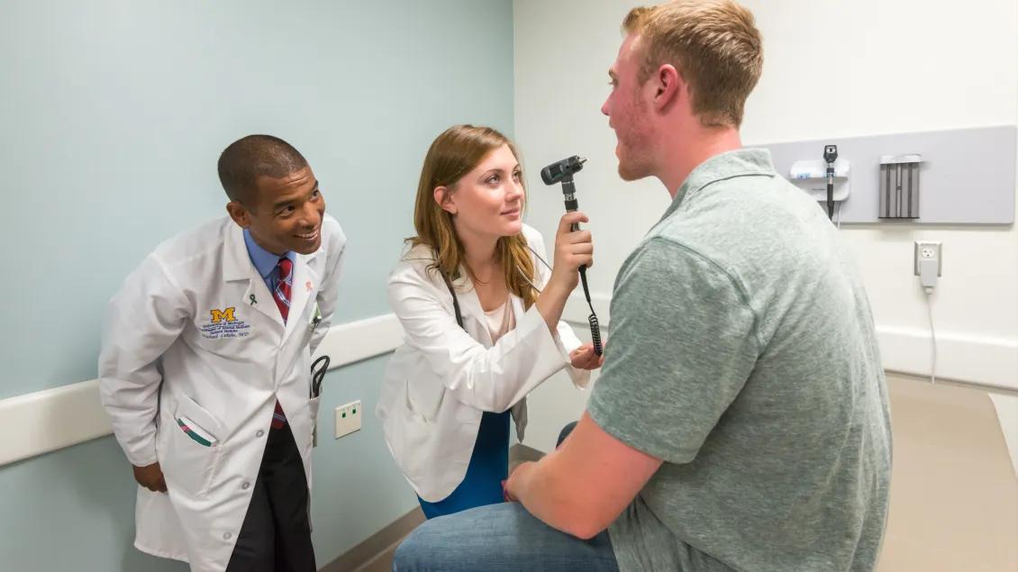Three people in a patient exam room