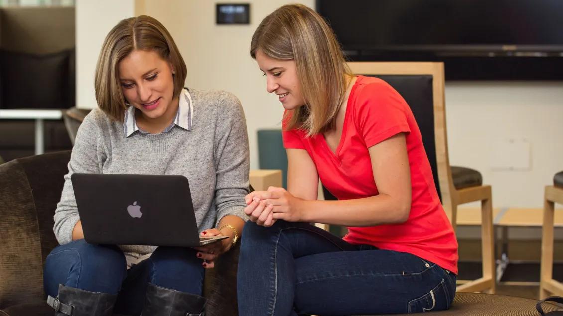 Two people working on a laptop