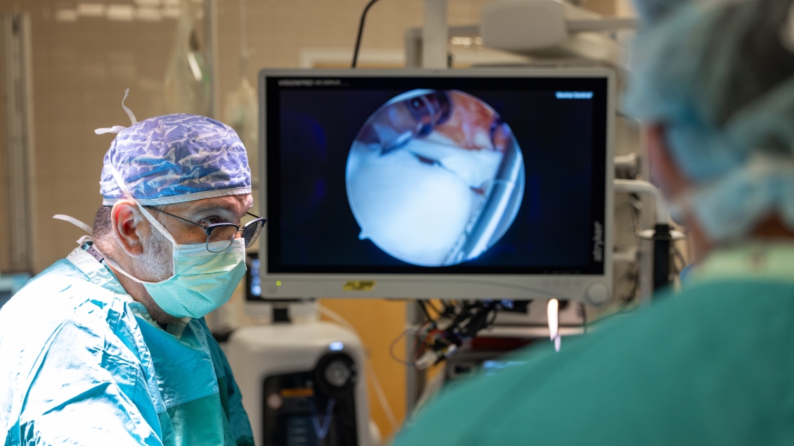 A surgeon is looking at a monitor.
