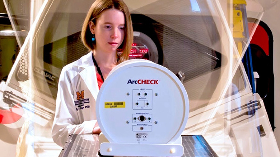 Radiation Oncology resident works in the lab at a machine