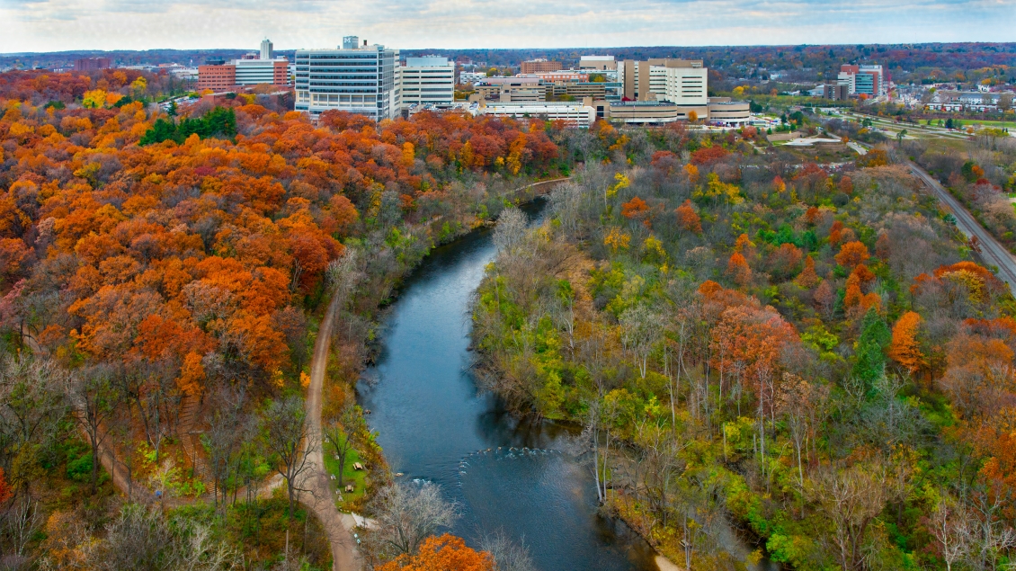Aerial of UM Medical Center with Huron River and fall trees in foreground