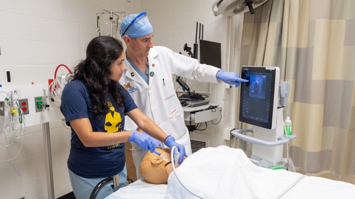 Anesthesiology resident works in the simulation lab with an instructor