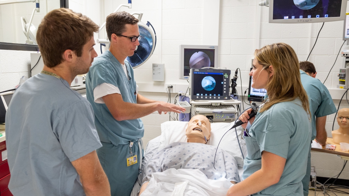 Three people training with a patient dummy