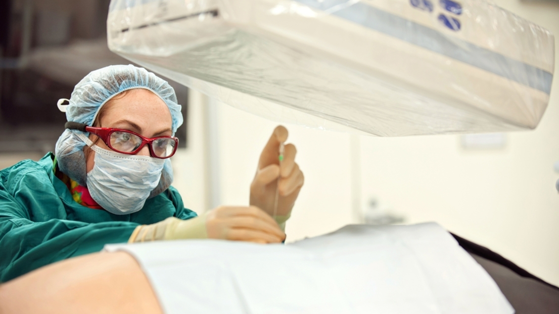 A person with a mask working in an operating room