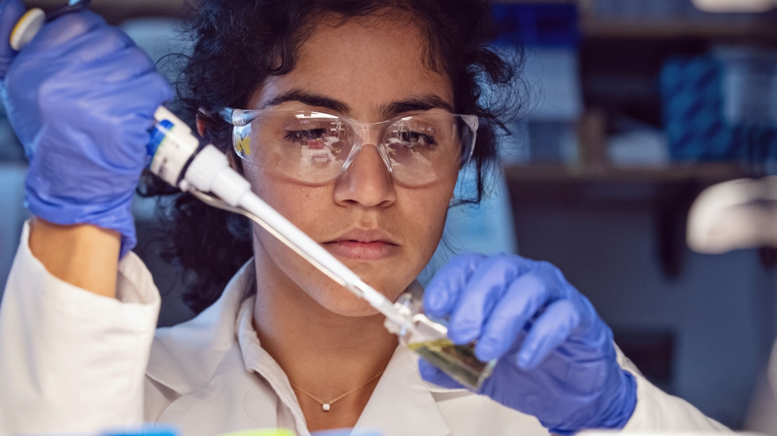 A close up of a woman working with lab equipment