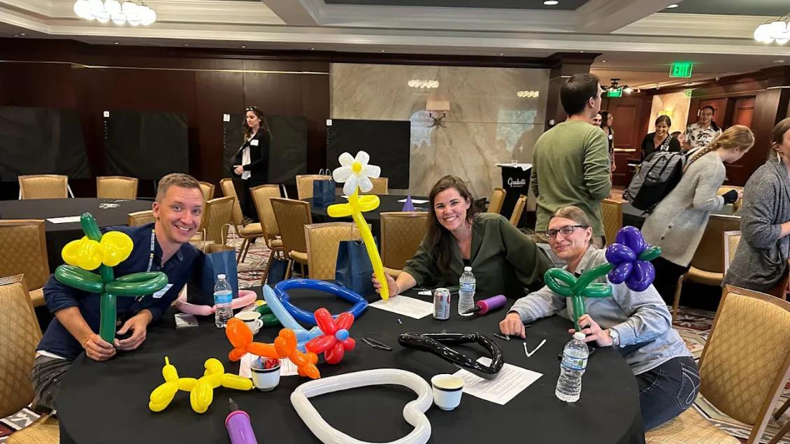 a group of people sitting at a table with balloons