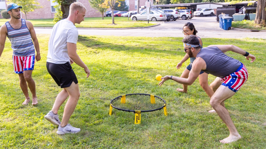 A group of people playing a yard game outside