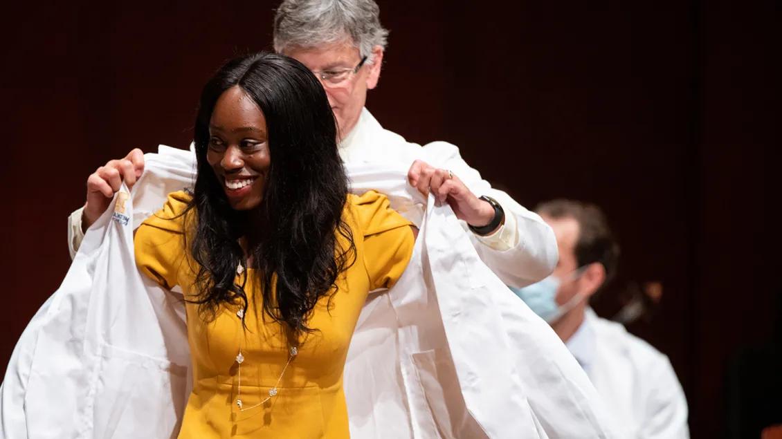 woman receiving white coat at U-M White Coat Ceremony