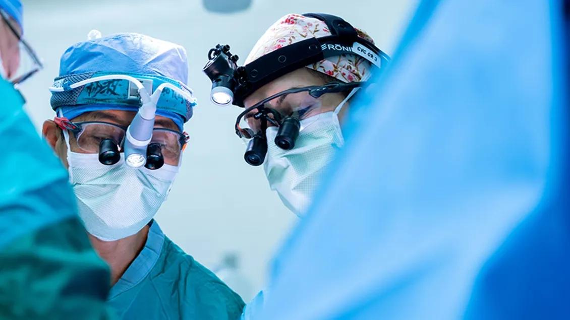 A close-up of two surgeons working