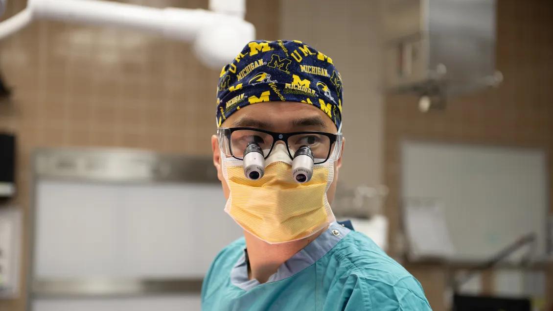 surgeon wearing uofM cap in OR