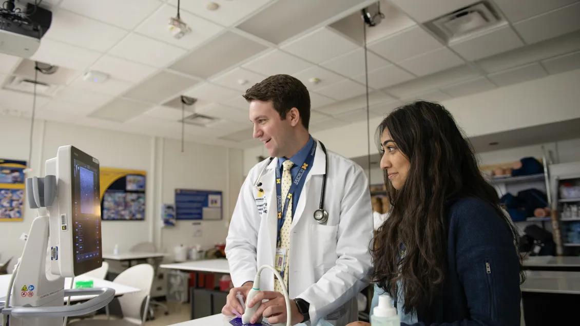 teacher smiles while helping student 