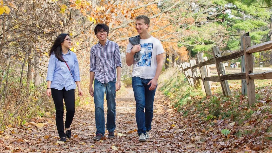 Three people walking on a nature trail in Ann Arbor