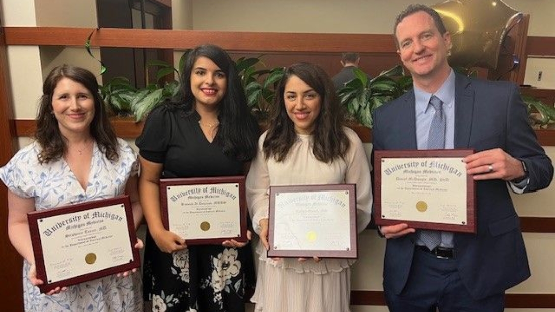 A group of fellows holding certificates