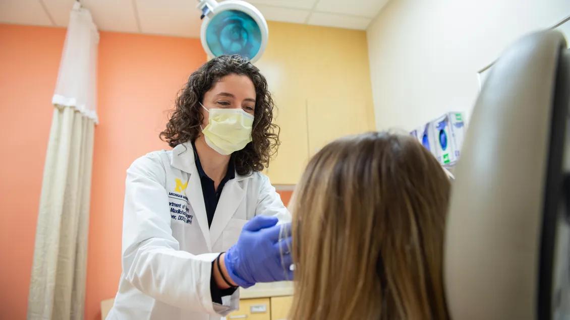 female doctor wearing masks gives patient examination 